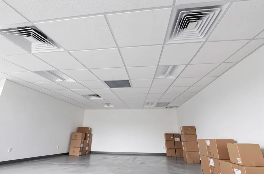 Faux plafond en plâtre terminé dans un bureau rénové, vue en contre-plongée montrant la finition professionnelle