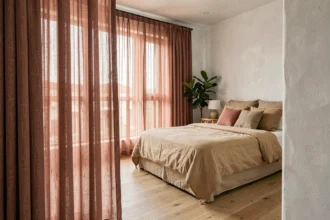 Chambre moderne avec rideaux superposés en rose poudré et terracotta associés à une literie en lin naturel